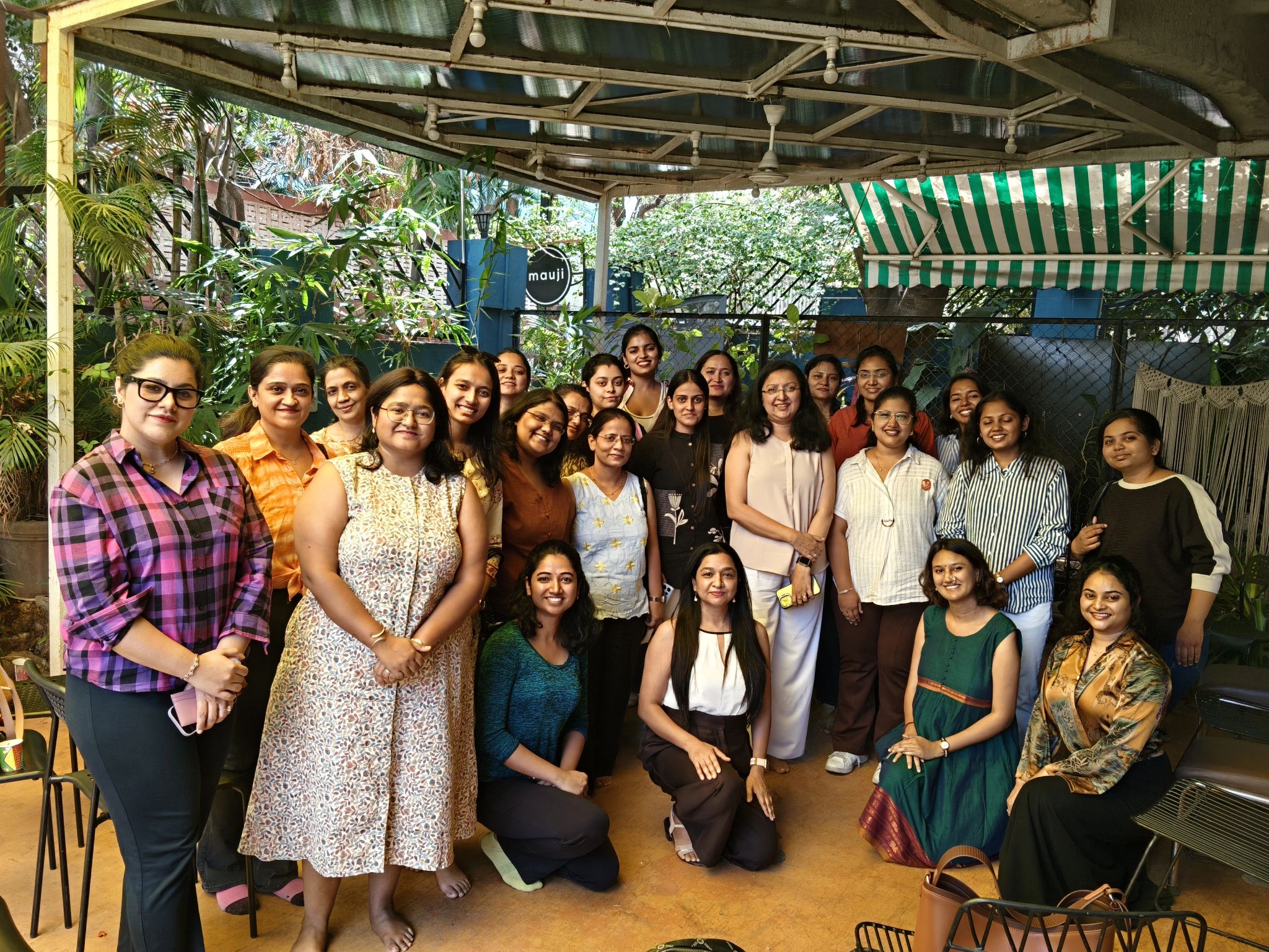Group photo of the eChai Women Founders Circle gathered at Mauji - The Time Cafe in Pune, women founders standing together under the cafe's open-air canopy